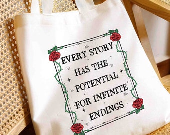 Op de afbeelding: Witte canvas draagtas met zwarte handvatten en een zwart ingelijst citaat dat luidt "Every story has the potential for infinite endings." Het citaat is omgeven door een zwarte wijnstok met rode rozen.