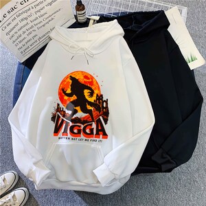 May include: White hoodie with a front graphic of a werewolf silhouette against a red moon and a castle. The word "VIGGA" is printed below the graphic in orange and black, with the text "BETTER NOT LET ME FIND IT!" below it. A black hoodie is next to it.