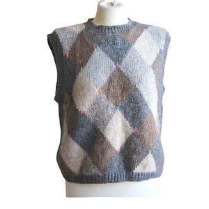 May include: A sleeveless knit sweater vest featuring a multi-colored argyle pattern in shades of gray, brown, and cream. The garment is accented with small, vibrant neon-colored dots placed at the intersections of the diamond-shaped pattern.