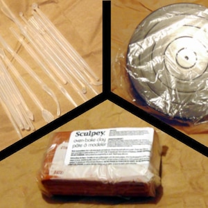 May include: A set of clear plastic sculpting tools, a brown block of Sculpey oven-bake clay, and a grey pottery turntable. The turntable is wrapped in plastic.