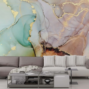 May include: Abstract wall art featuring a swirling pattern of teal, brown, and gold paint. The art is displayed on a wall behind a gray sofa with white throw pillows.