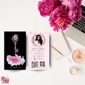 May include: Pink and black business card with a key and house design. The card includes the name Andrea Gilbert, Real Estate Agent, company name, phone number, email address, website address, and social media icons.