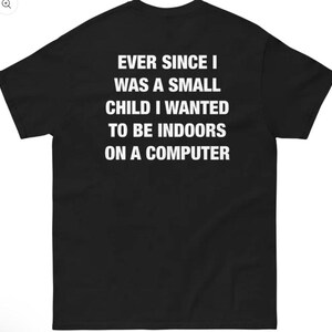 May include: A black short-sleeved t-shirt featuring white text printed on the back that reads: EVER SINCE I WAS A SMALL CHILD I WANTED TO BE INDOORS ON A COMPUTER. The garment has a crew neckline and a standard fit with short sleeves.
