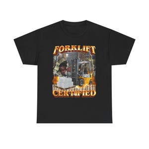 May include: Black t-shirt with a graphic of a person operating a forklift in a warehouse. The text "FORKLIFT CERTIFIED" is printed in yellow and orange on the shirt.