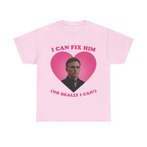 Puede incluir: Camiseta rosa con un gráfico en forma de corazón que presenta la cara de un hombre y el texto "Puedo arreglarlo (de verdad que puedo!)"