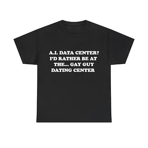 May include: A black short-sleeved t-shirt featuring white text printed on the chest that reads: A.I. DATA CENTER? I'D RATHER BE AT THE... GAY GUY DATING CENTER. The garment has a crew neckline and a standard fit with short sleeves.