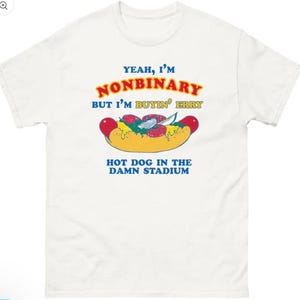 Könnte beinhalten: Weißes T-Shirt mit einer Abbildung eines Hotdogs und Text. Der Text lautet "YEAH, I'M NONBINARY BUT I'M BUYIN' ERRY HOT DOG IN THE DAMN STADIUM" in Blau, Rot und Gelb. Die Hotdog-Grafik hat rote, gelbe und grüne Akzente.