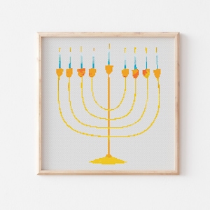 May include: A gold menorah with nine candles, each with a blue and orange flame. The menorah is framed in a light wood frame.