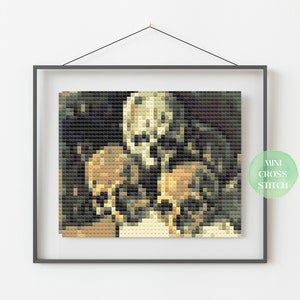 May include: A cross stitch pattern featuring a close-up of three skulls in a dark background. The skulls are in shades of brown, white, and black. The pattern is framed in a black frame.