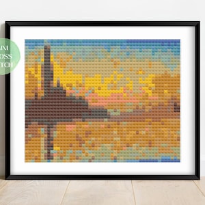 May include: A cross stitch pattern of a sunset over a city skyline. The pattern is made up of small squares of different colors, creating a pixelated effect. The colors in the pattern are mostly yellow, orange, and blue.