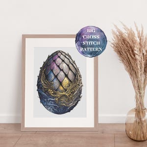 May include: A cross stitch pattern of a dragon egg with a gold and purple design. The egg is surrounded by a decorative border of gold and silver.