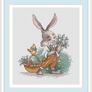 Może przedstawiać: Haft krzyżykowy przedstawiający królika trzymającego bukiet niebieskich kwiatów, z ptakiem siedzącym na koszu z podobnymi kwiatami. Królik ma na sobie brązowe spodnie, niebieską koszulę i biały kołnierzyk. Tło to jasny zielono-niebieski wzór krzyżykowy.