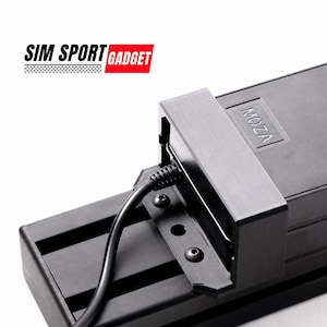 Könnte beinhalten: Ein schwarzes elektronisches Gerät mit dem Text "MOZA" und einem angeschlossenen Kabel. Das Gerät ist Teil eines größeren Systems, möglicherweise für Sim-Racing oder Gaming. Das Logo "SIM SPORT GADGET" ist oben links sichtbar.