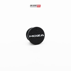Op de afbeelding: Een zwart, rond product met het witte woord "MOZA" erop gedrukt. Het product heeft een getextureerd oppervlak en een zwarte rand. Het logo "SIM SPORT GADGET" staat linksboven.