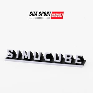 以下が含まれることがあります： 白い表面に「SIMUCUBE」という単語を綴る黒と白のプラスチック製の文字。文字は盛り上がっており、丸みを帯びたエッジを持っています。