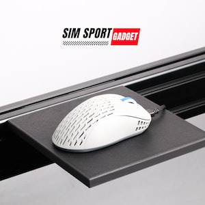 May include: A white computer mouse with a black cord sits on a black mousepad attached to a black metal desk rail. The mousepad is attached to the desk rail with screws. The text "SIM SPORT GADGET" is visible above the mousepad.