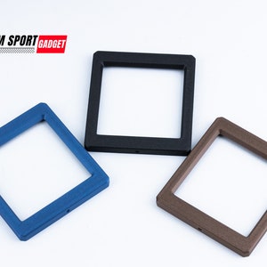 May include: Three square frames in blue, black, and brown. The frames have a textured surface and a square opening in the center. The text "SIM SPORT GADGET" is in the upper left corner.