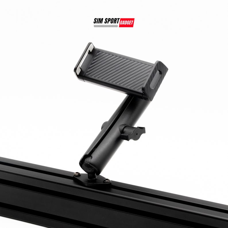 May include: A black phone mount with a carbon fiber textured phone holder. The mount is attached to a black metal rail. The logo "SIM SPORT GADGET" is in the top right corner.