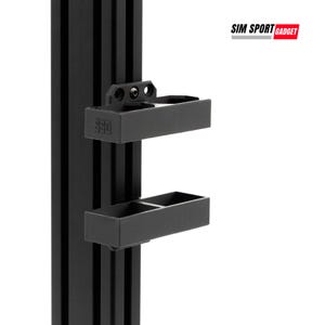 May include: Black metal bracket with two rectangular trays attached to a vertical support. The bracket is designed to hold items. The logo "SIM SPORT GADGET" is visible in the upper right corner.