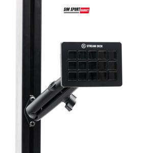 Puede incluir: Un Stream Deck negro con 15 botones cuadrados, montado en un brazo ajustable negro. El Stream Deck está fijado a un poste vertical negro. El logotipo "SIM SPORT GADGET" está en la esquina superior izquierda.