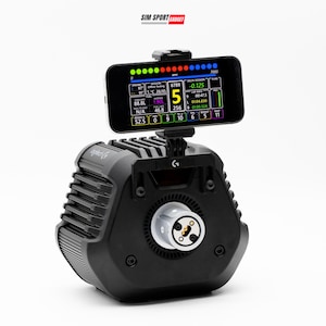 May include: A black racing wheel base with a mounted smartphone display showing telemetry data including RPM, fuel, and lap information. The device features a central circular connector and a top-mounted phone holder. The text SIM SPORT GADGET is visible.