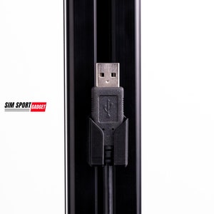 May include: A black USB cable is routed through a black cable management system. The cable is connected to a USB port.