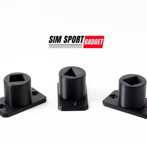 May include: Three black plastic mounts with different shaped holes. The mounts are designed for use with a simulator racing setup. The text "SIM SPORT GADGET" is visible above the mounts.
