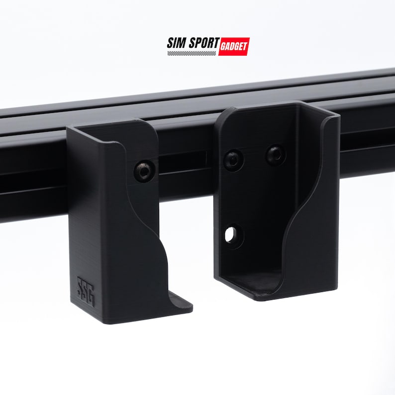 Puede incluir: Primer plano de soportes met&aacute;licos negros fijados a un riel negro. Los soportes tienen un dise&ntilde;o curvo y est&aacute;n asegurados con tornillos. El texto "SIM SPORT GADGET" se muestra en un rect&aacute;ngulo rojo y blanco.