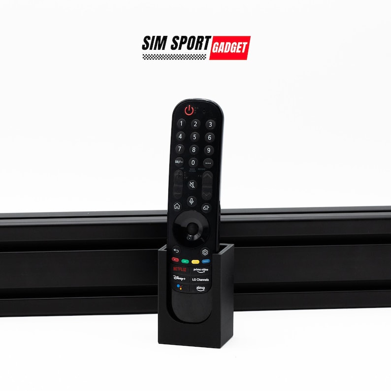 May include: Black remote control holder with a black remote control inside. The holder has a label that says "Netflix, Prime Video, Disney+, LG Channels, Sling".