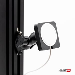 May include: A black phone mount with a white circular charging pad and a gray cable. The mount is attached to a black vertical support. The text "SIM SPORT GADGET" is visible in the bottom right corner.