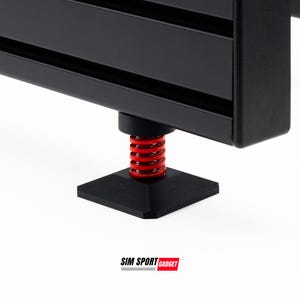 May include: Close-up of a black metal component with a red spring and a square base. The component is part of a larger structure, possibly a piece of equipment or furniture. The logo "SIM SPORT GADGET" is visible.