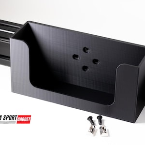 May include: Black plastic storage box with four holes for mounting. The box is attached to a black metal track. The box is labeled "SIM SPORT GADGET".