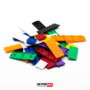 May include: Assortment of colorful plastic tiles with rounded edges and small holes. The tiles are in various colors, including red, orange, yellow, green, blue, purple, and white. The tiles are arranged in a pile on a white surface.
