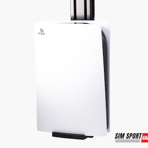 May include: A white PlayStation 5 console mounted on a wall with a black bracket. The console has a white front panel with the PlayStation logo and a black side panel.