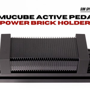以下が含まれることがあります： シムキューブアクティブペダル用の黒い電源ブロックホルダー。ホルダーは金属製で、黒い仕上げになっています。電源ブロックはホルダーに差し込まれており、黒いケーブルで固定されています。