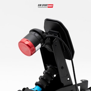 May include: A black sim racing pedal assembly featuring a prominent red cylindrical adjustment knob with a logo on the end. The unit includes a vertical metal frame, a black pedal face, and a black cable. The text SIM SPORT GADGET appears above.