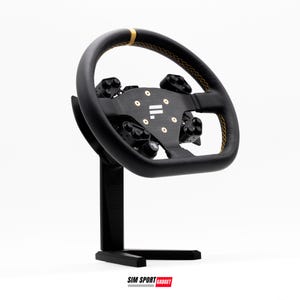 May include: Black racing wheel with gold stitching and accents, mounted on a black stand. The wheel features multiple buttons and a central hub with gold-colored screws. The base has the text "SIM SPORT GADGET".