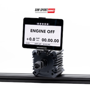 Puede incluir: Un componente de simulador de carreras negro y plateado con una pantalla que muestra "ENGINE OFF" y datos de cronometraje. La pantalla está montada sobre un motor con la marca "FANATEC" visible. El logotipo "SIM SPORT GADGET" está en la esquina superior derecha.