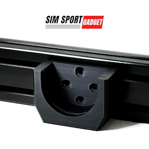 May include: Black metal bracket with five holes and a curved edge. The bracket is attached to a black metal rail. The text "SIM SPORT GADGET" is visible in the background.