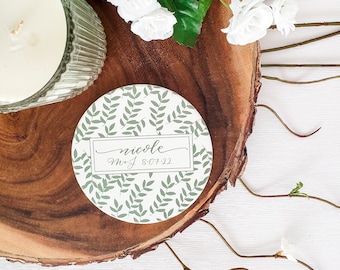 May include: A round white coaster with a green leafy pattern and the text "nicole M+J 8-07-22" in a black rectangle.