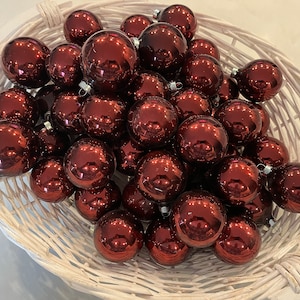 A White Basket Full of 50 Vintage Burgundy Mercury Ornaments