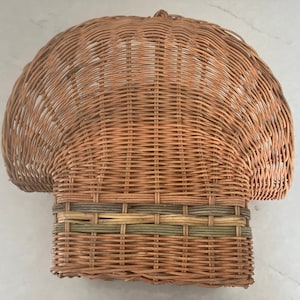 May include: A woven wicker basket with a rounded top and a brown and green striped band around the rim.