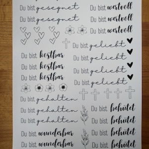 May include: Black and white printable stickers with inspirational quotes in German. The quotes include "Du bist gesegnet", "Du bist wertvoll", "Du bist kostbar", "Du bist geliebt", "Du bist gehalten", "Du bist beh&uuml;tet", and "Du bist wunderbar".