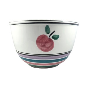 Puede incluir: Tazón de mezcla de cerámica blanca con un diseño de manzana roja y hojas verdes pintadas a mano. El tazón tiene un borde negro y rayas multicolores alrededor de la base.