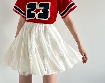 Falda de encaje blanca de ensueño: elegancia vintage para un look deportivo y romántico.