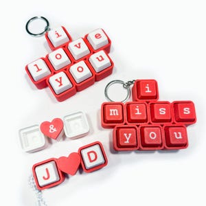 Puede incluir: Llaveros de teclas rojas y blancas que deletrean "I love you" e "I miss you". Llaveros adicionales incluyen iniciales y un símbolo de corazón. Cada llavero tiene un llavero plateado.