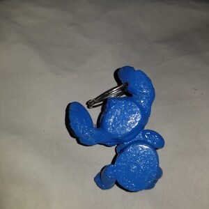 May include: A blue plastic crab keychain with a silver metal ring.