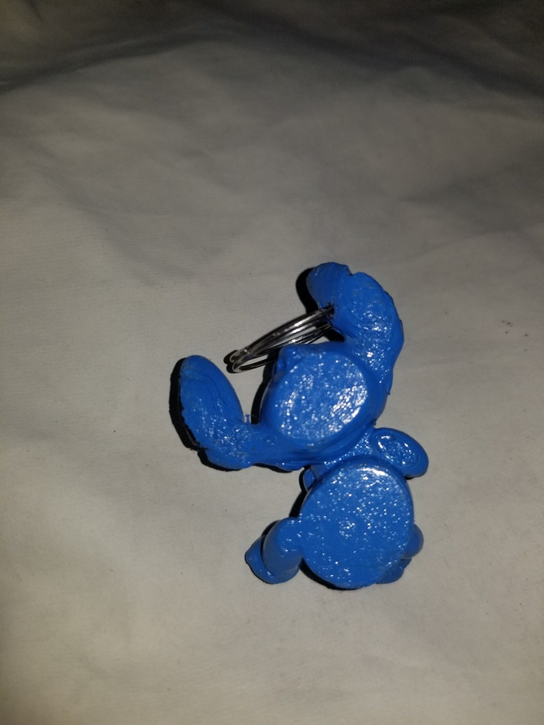 May include: A blue plastic crab keychain with a silver metal ring.