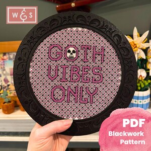 Puede incluir: Un patrón de punto de cruz en blanco y negro con una calavera rosa y el texto "GOTH VIBES ONLY". El patrón está enmarcado en un marco circular negro con un borde decorativo. El patrón es un patrón de punto negro PDF.