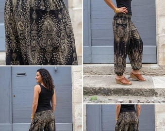 May include: Black harem pants featuring a gold-toned intricate paisley and mandala-inspired pattern. These pants have a high, elasticized smocked waistband, a relaxed fit through the legs, and gathered elastic cuffs at the ankles.